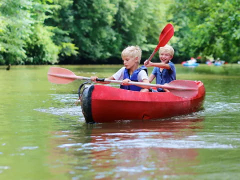 two kids in a red canoe