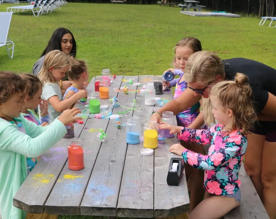 a group of children playing with water bottles on a table