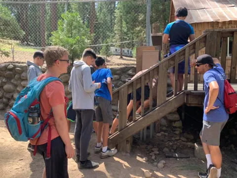 a group of people standing around a wooden structure