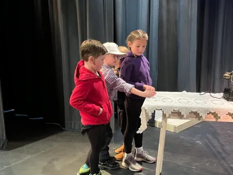 a group of boys standing next to a table with a white tablecloth