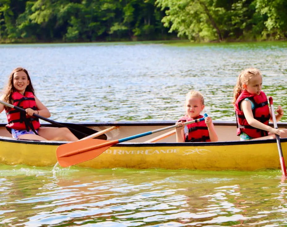 a group of kids in a canoe