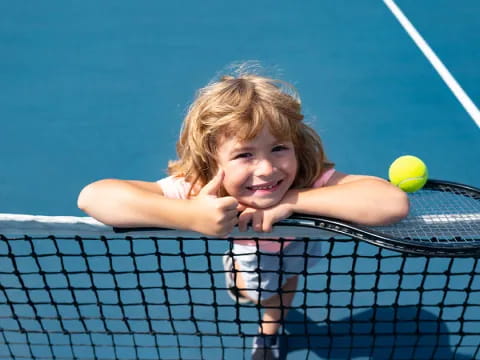 a girl hitting a ball with a tennis racket