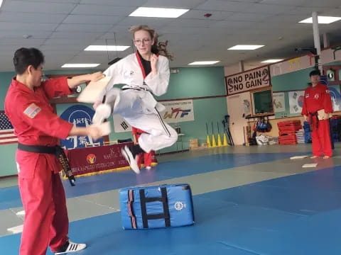 a man holding a woman in a karate uniform