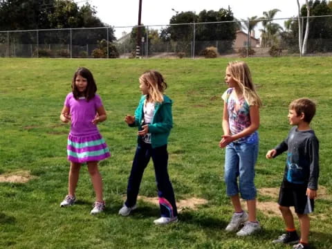 a group of children standing on grass