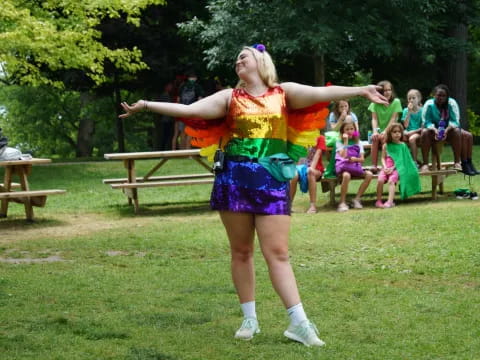 a woman in a colorful dress dancing in a park