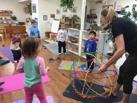 a person and children playing with a toy