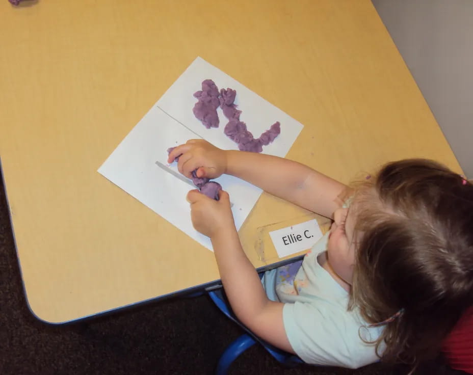 a girl drawing on a paper