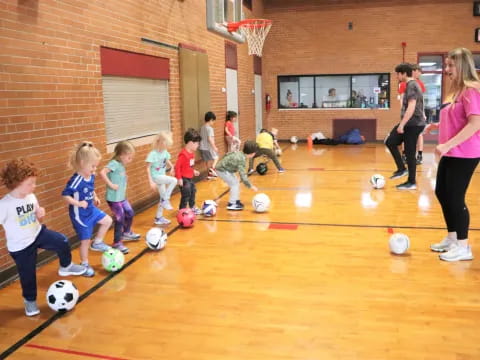 a group of kids playing with football balls