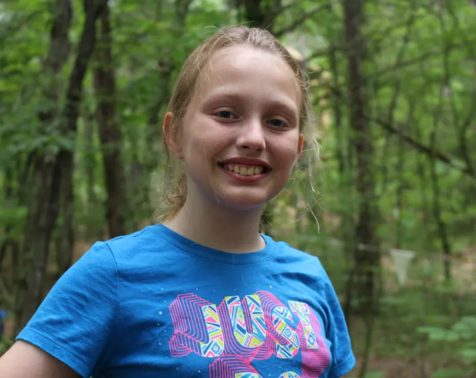 a girl smiling in the woods