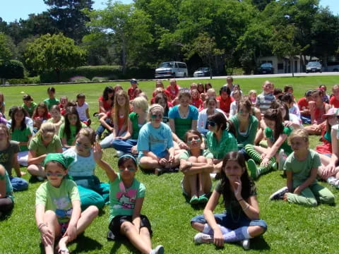 a group of people sitting on the grass