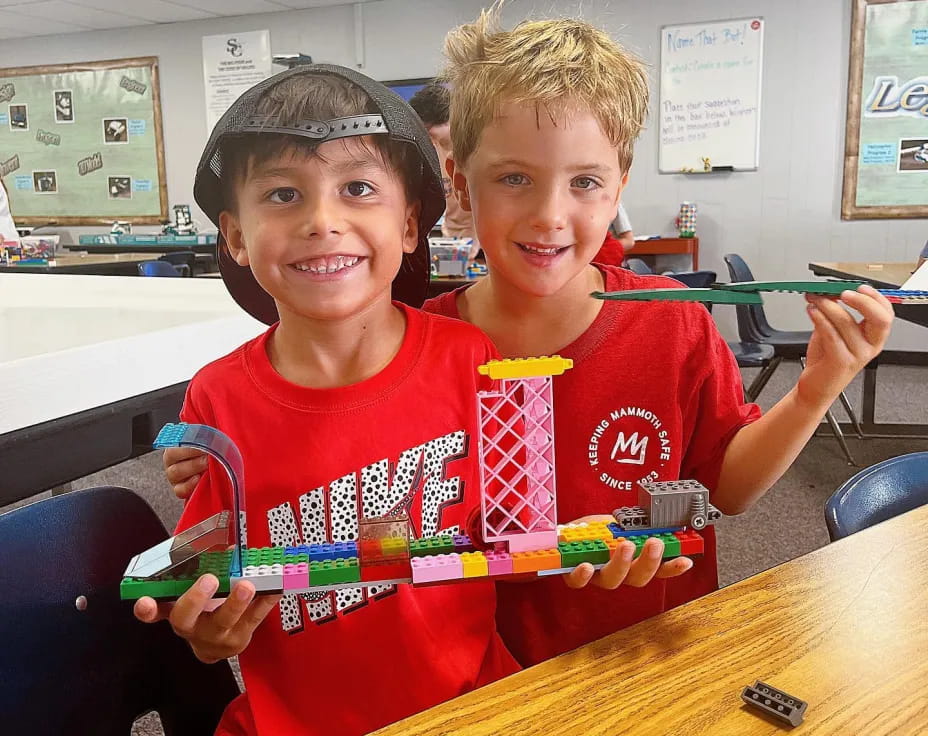 a couple of boys holding a toy