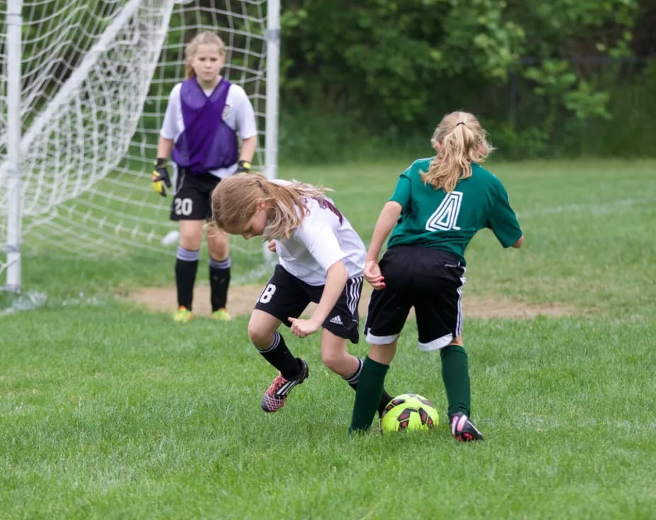 girls playing football on a field