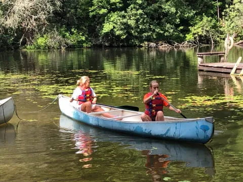 a couple of kids in a canoe on a river