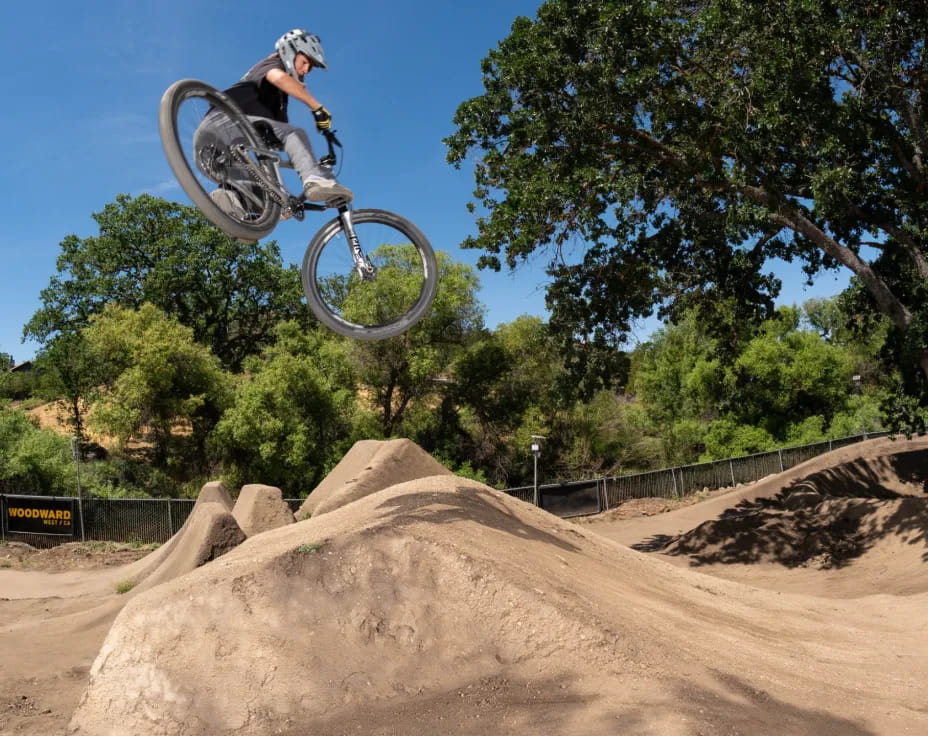 a man riding a bike over a ramp