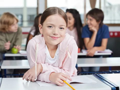 a young girl sitting at a desk