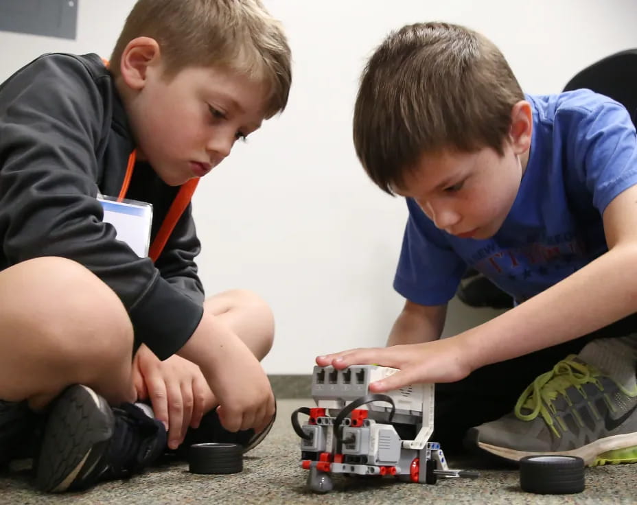 a couple of boys playing with a toy train