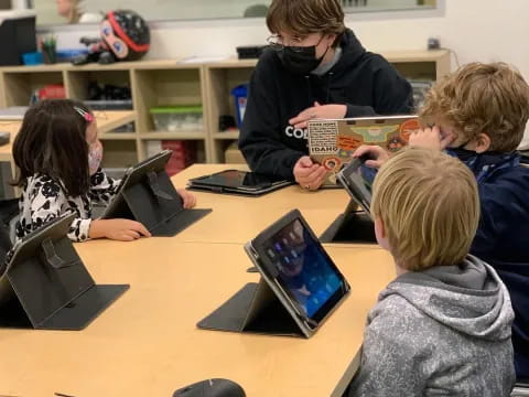 a group of children using laptops