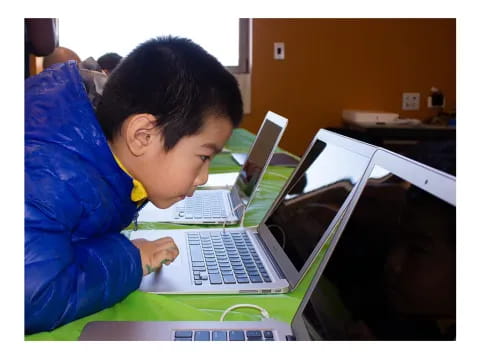 a young boy using a laptop