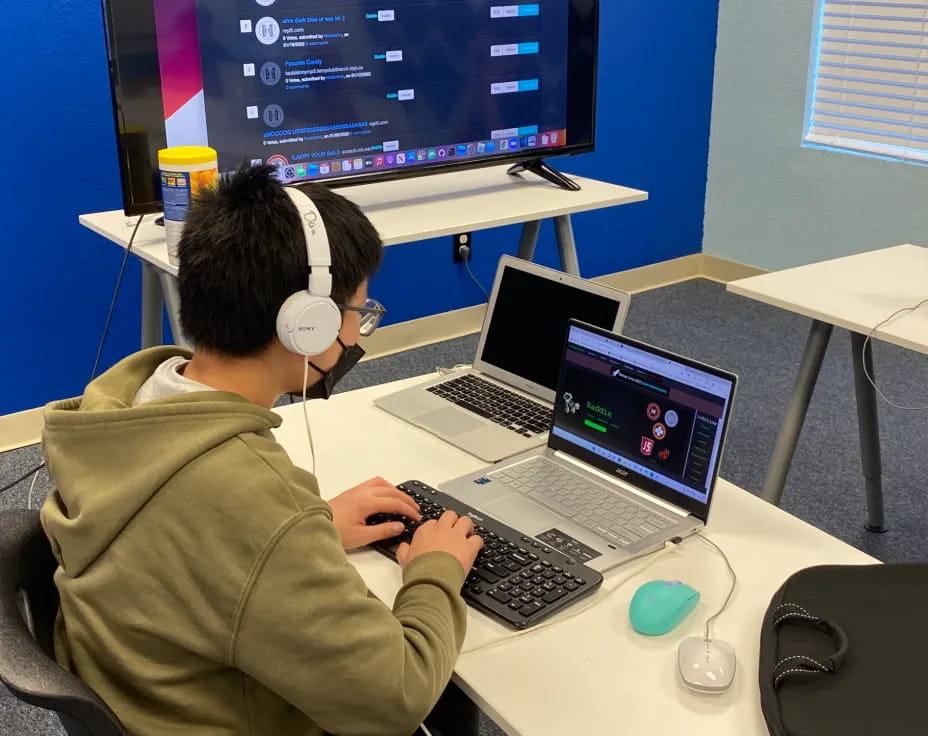 a man wearing headphones and using a laptop