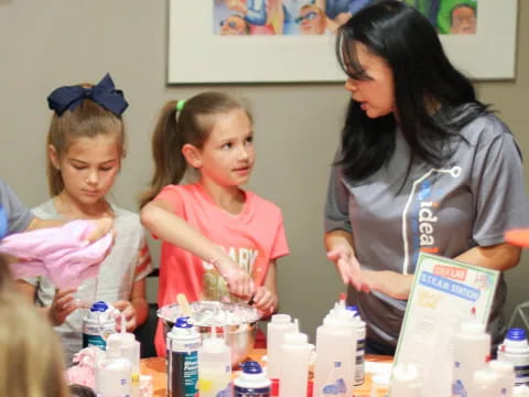 a person and a girl at a table with bottles of liquid