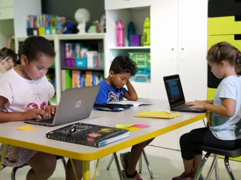a group of kids using laptops