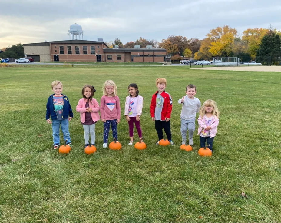a group of children standing on a field with balls