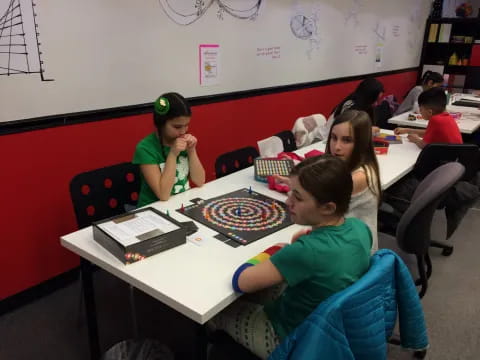 a group of children sitting at a table eating pizza