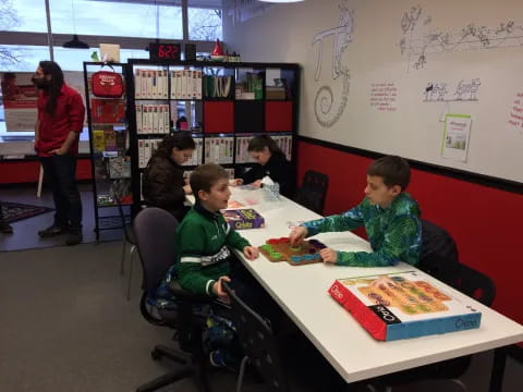 a group of children sitting at a table in a library