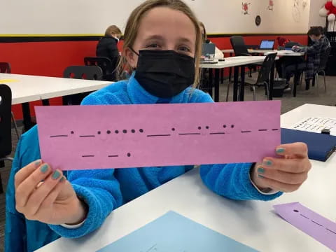 a boy holding a purple paper