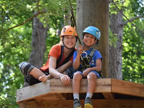 a person and a boy on a tree branch