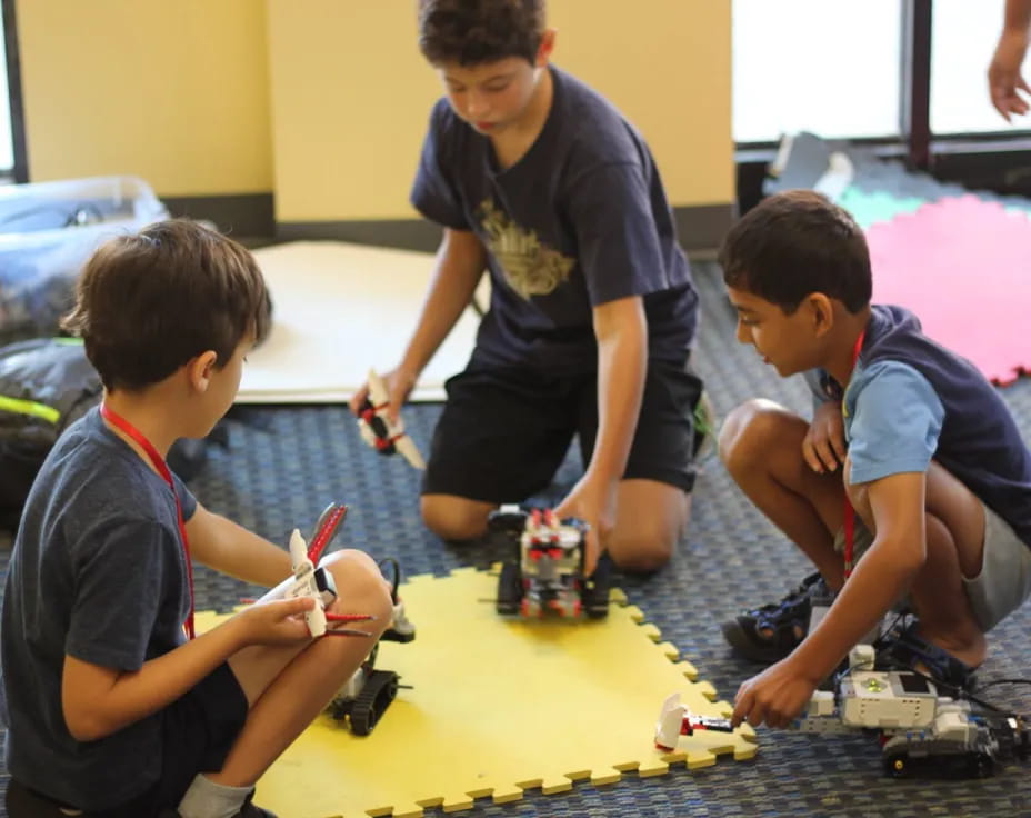 a group of boys playing with toy cars