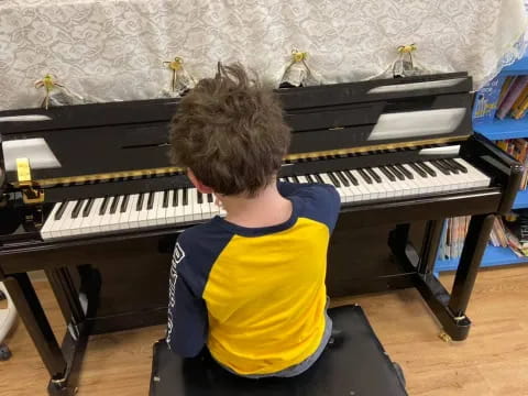 a boy playing a piano