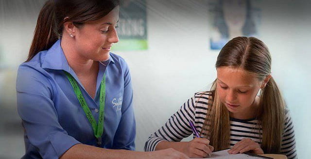 a woman and a girl looking at a book