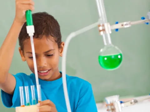 a young boy working on a test tube