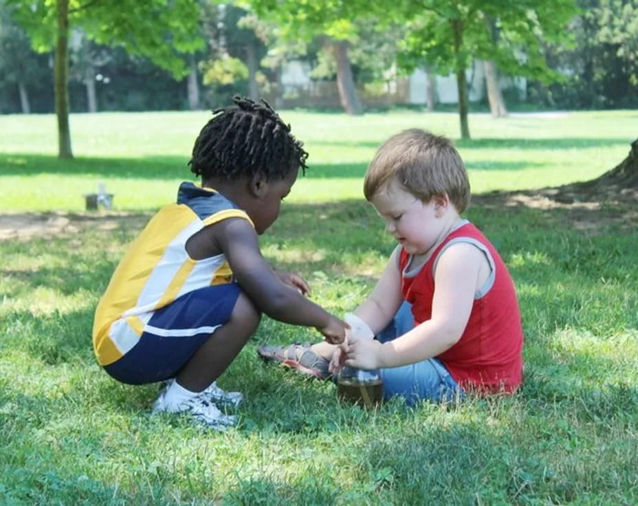 two boys playing in the grass