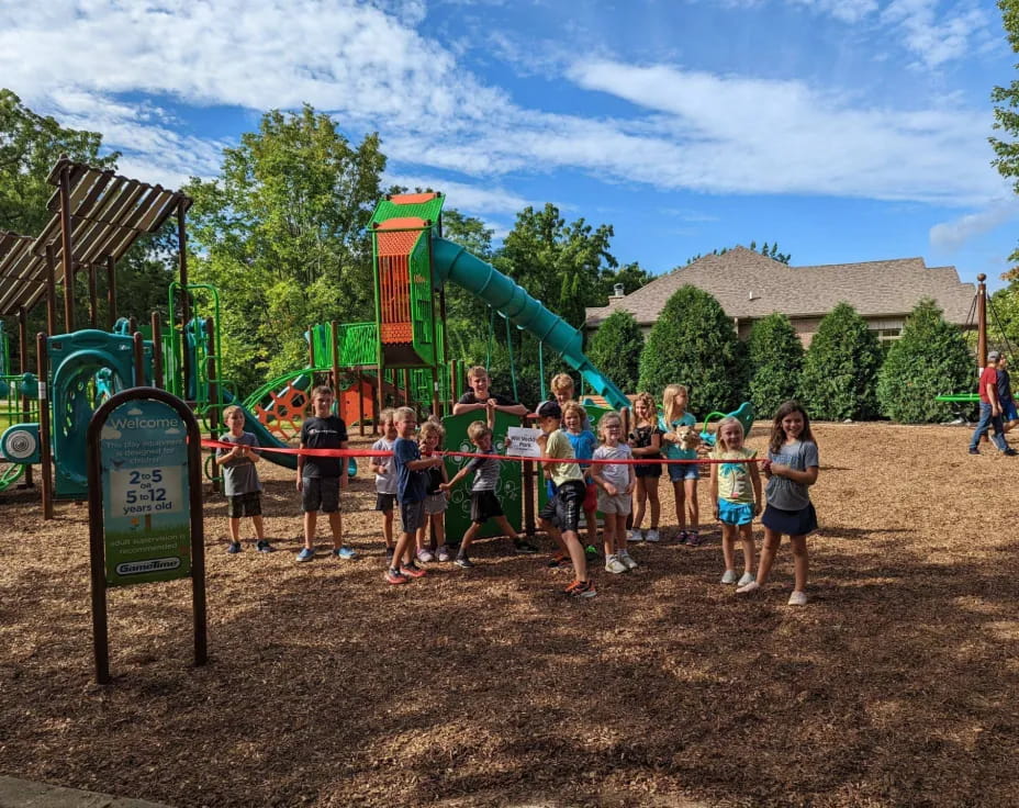 a group of people posing for a photo in front of a playground