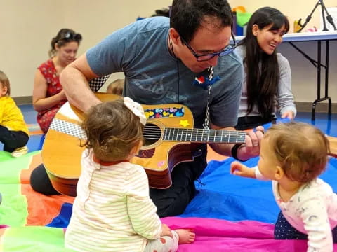 a man playing guitar with children