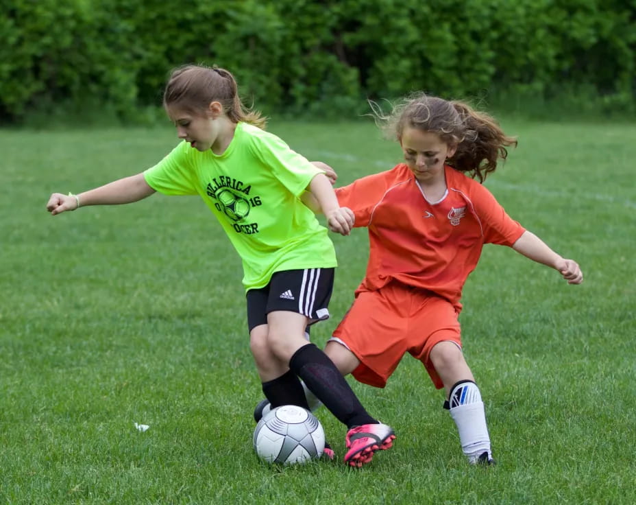 girls playing football on a field