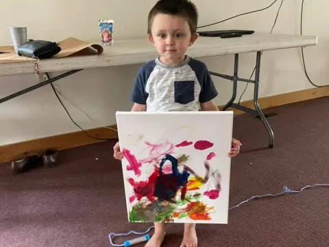 a boy holding a drawing