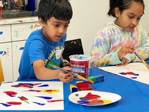 a couple of children painting