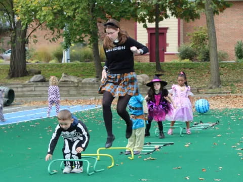 a person and children playing in a yard