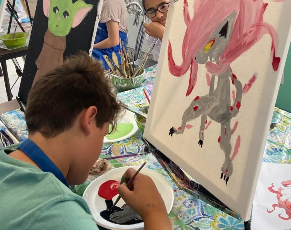 a boy painting a snowman