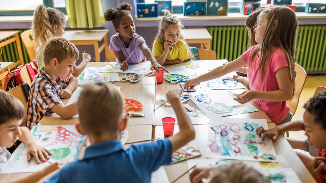 a group of children sitting around a table