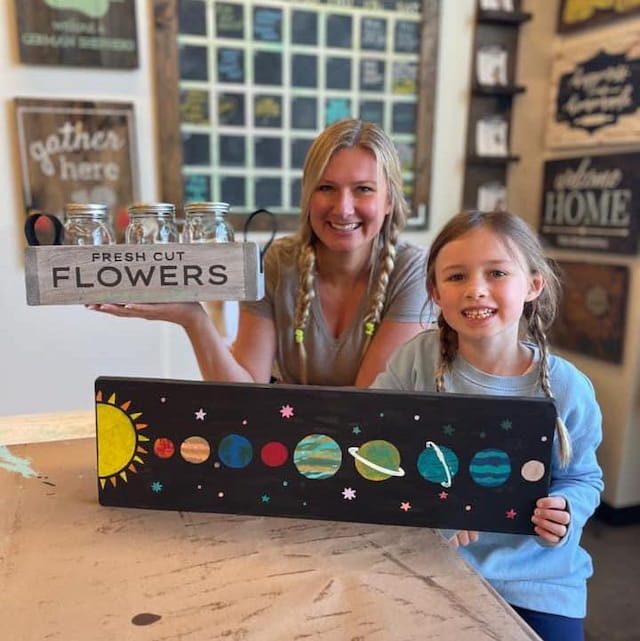 a woman and a girl holding a board