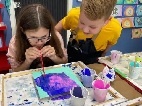 a couple of children painting