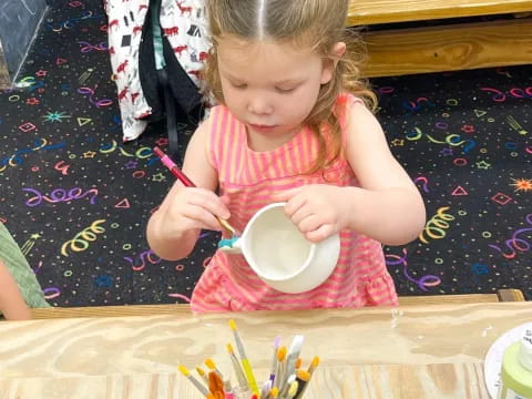 a little girl eating from a bowl