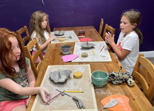 a group of girls sitting at a table with food