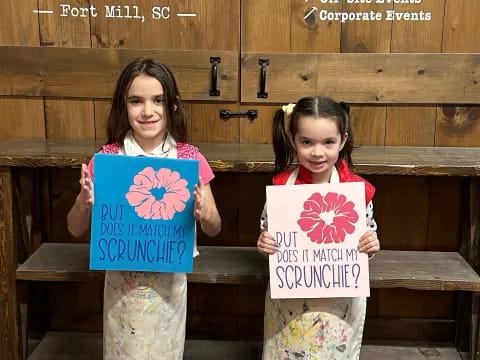 two girls holding signs
