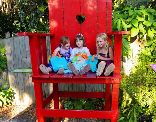 a group of girls sitting on a red play structure