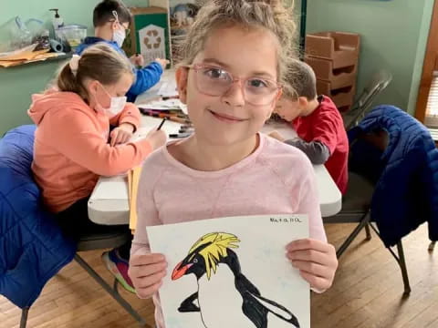 a girl holding a drawing